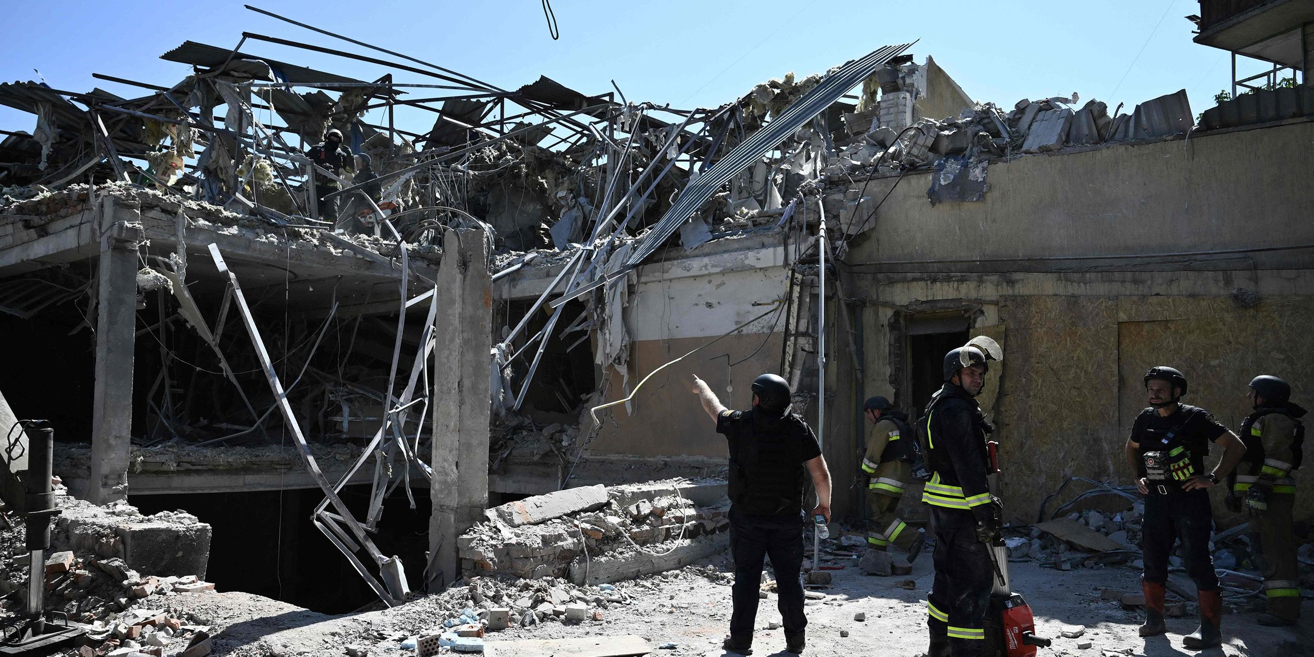 Ukrainische Rettungskräfte stehen vor einem zerstörten Hotel in Kramatorsk.
