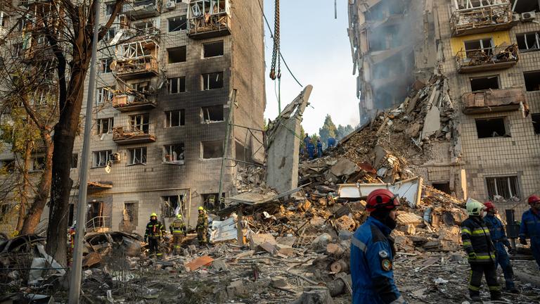 Ukrainische Rettungskräfte suchen in den Trümmern eines russischen Raketenangriffs auf ein Wohnhaus in Kiew nach Menschen, die durch die Zerstörung am 17.06.2025 möglicherweise verschüttet wurden.