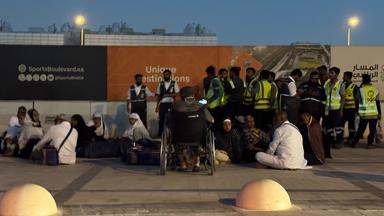 Menschen versammeln sich vor einer U-Bahn-Station an der Straße zum King-Chalid-Airport in Riad, Saudi-Arabien.