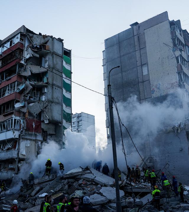 Rettungskräfte beseitigen die Trümmer eines Hauses, das nach einem russischen Angriff auf ein Wohnviertel schwer beschädigt wurde.