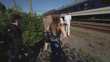 Ukraine: Menschen stehen vor einem Zug, der mitten auf der Strecke halten musste.