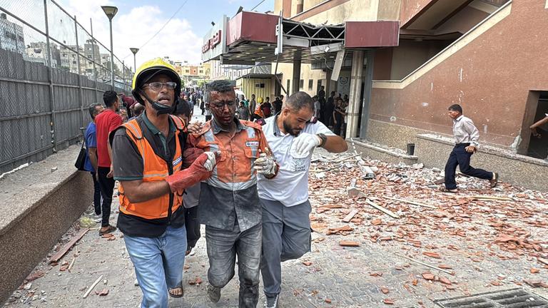 Verletzte Palästinenser werden nach israelischen Angriffen auf den Nasser-Krankenhauskomplex von Anwohnern aus dem Nasser-Krankenhaus getragen