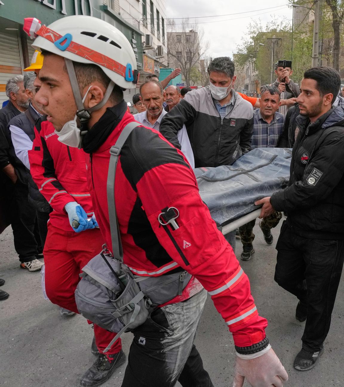 Mitglieder des iranischen Roten Halbmondes tragen einen Leichensack mit einem Todesopfer eines US-israelischen Angriffs in Teheran.