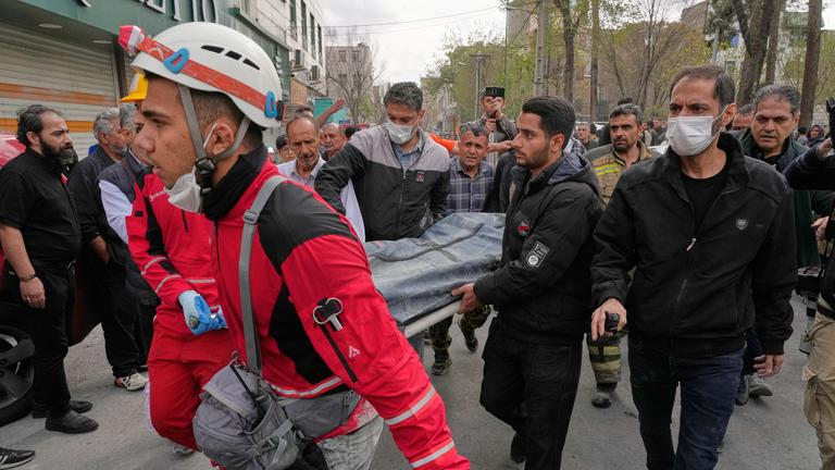 Mitglieder des iranischen Roten Halbmondes tragen einen Leichensack mit einem Todesopfer eines US-israelischen Angriffs in Teheran.