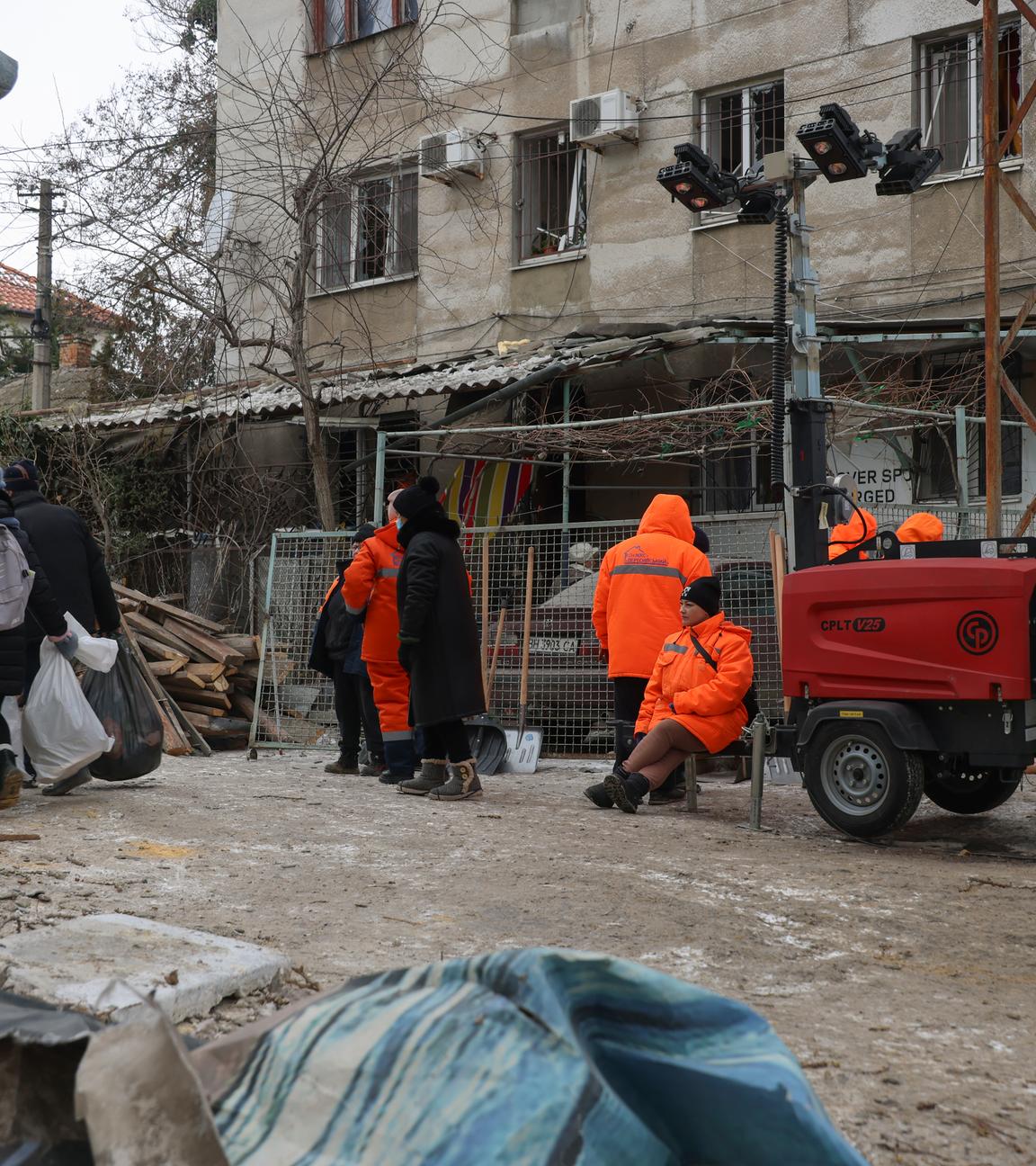 Ukrainische Einsatzkräfte und Arbeiter an einem beschädigten Wohnhaus nach einem russischen Drohnenangriff in Odesa.