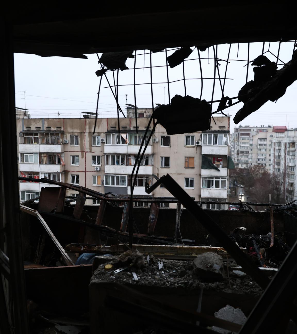 Blick auf ein Wohnviertel durch das zerbrochene Fenster eines von einer russischen Drohne getroffenen Wohngebäudes in Saporischschja, Ukraine.