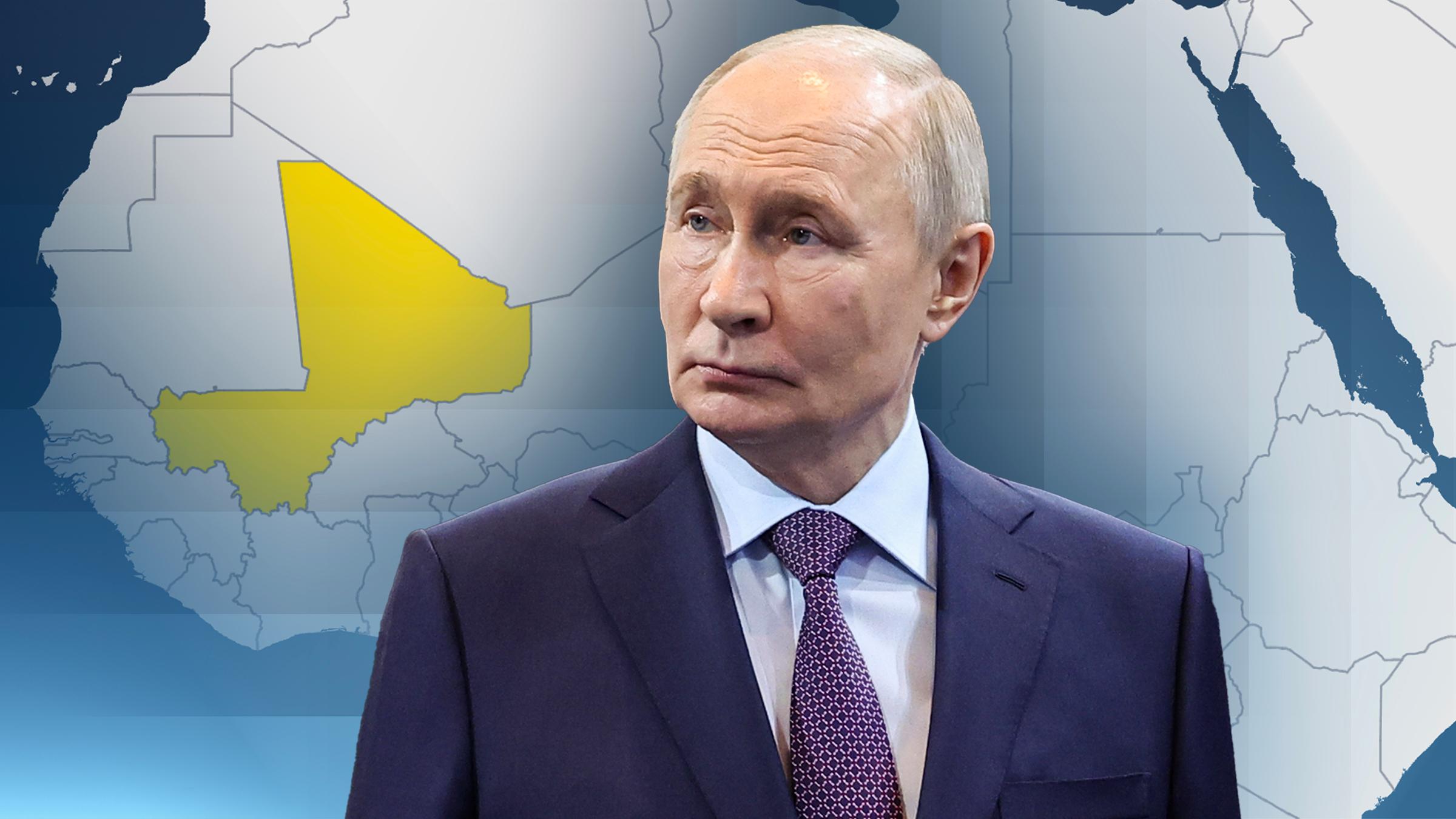 Der russische Präsident Putin. Hinter ihm eine Karte des afrikanischen Kontinens, bei der das Land Mali gelb markiert ist.