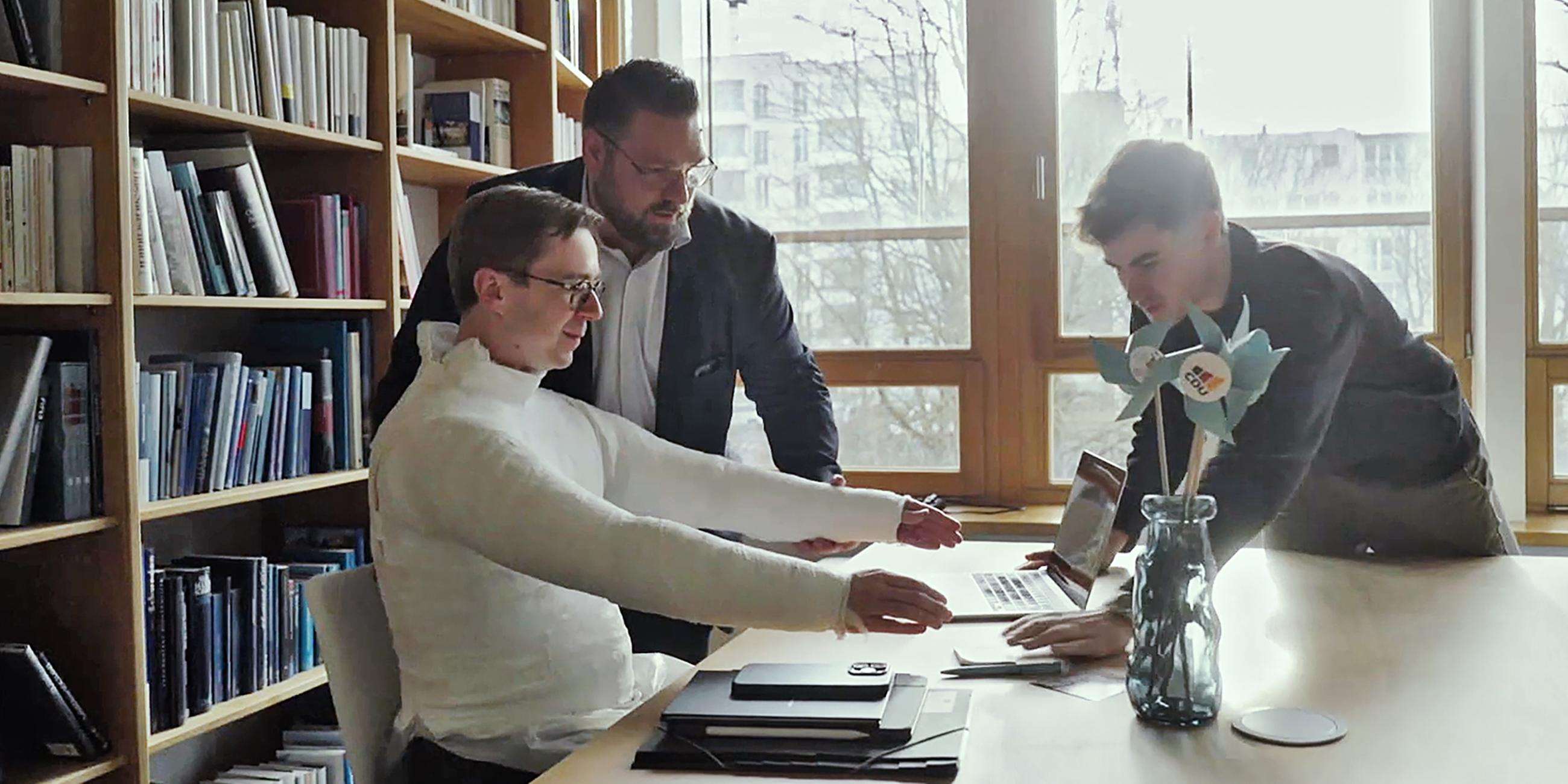 Philipp Amthor sitzt an seinem Schreibtisch, sein ganzer Oberkörper inklusive der Arme ist eingegibst.