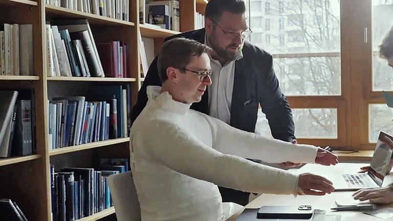 Philipp Amthor sitzt an seinem Schreibtisch, sein ganzer Oberkörper inklusive der Arme ist eingegibst.