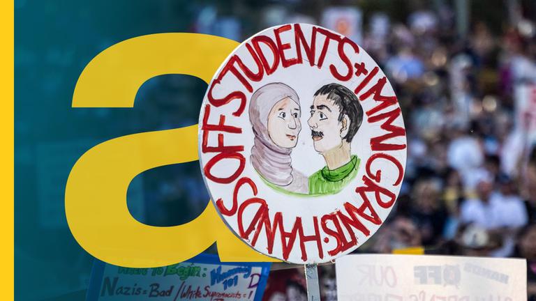 Plakat auf einem Protest, auf dem steht "Hands off students and immigrants"