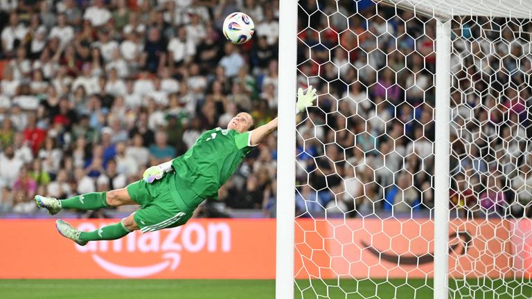 Torfrau Ann-Katrin Berger hält im DFB-Trikot spektakulär einen Ball.