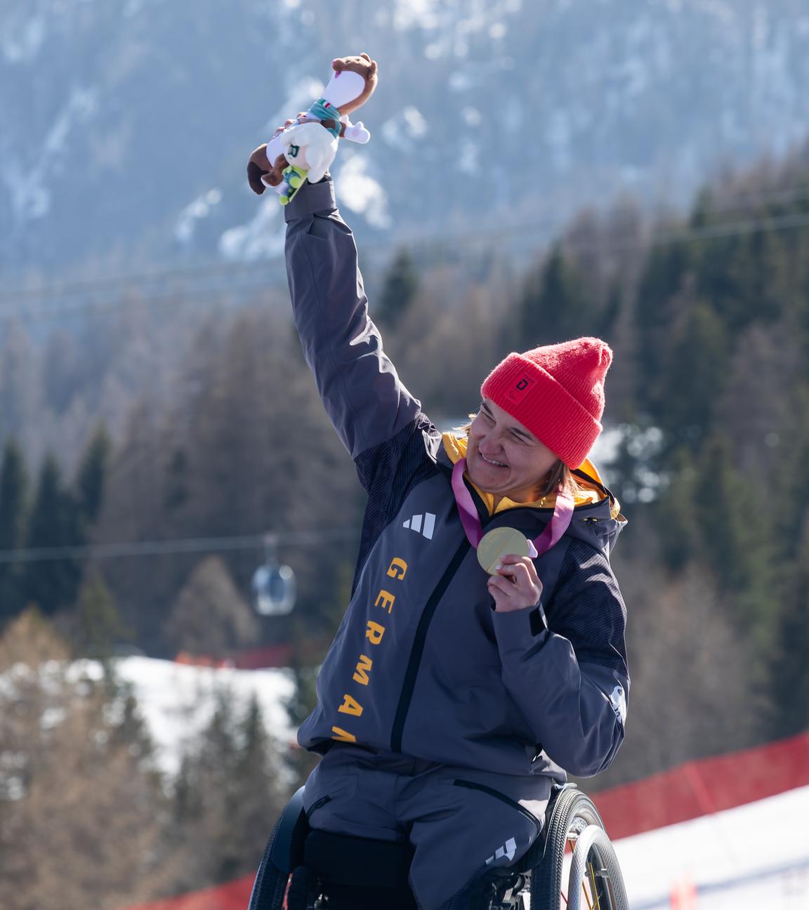 Die deutsche Monoskibobfahrerin Anna-Lena Forster präsentiert jubelnd ihre Goldmedaille nach der Abfahrt im Para Ski Alpin.