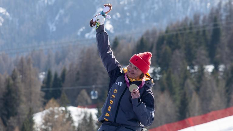 Die deutsche Monoskibobfahrerin Anna-Lena Forster präsentiert jubelnd ihre Goldmedaille nach der Abfahrt im Para Ski Alpin.
