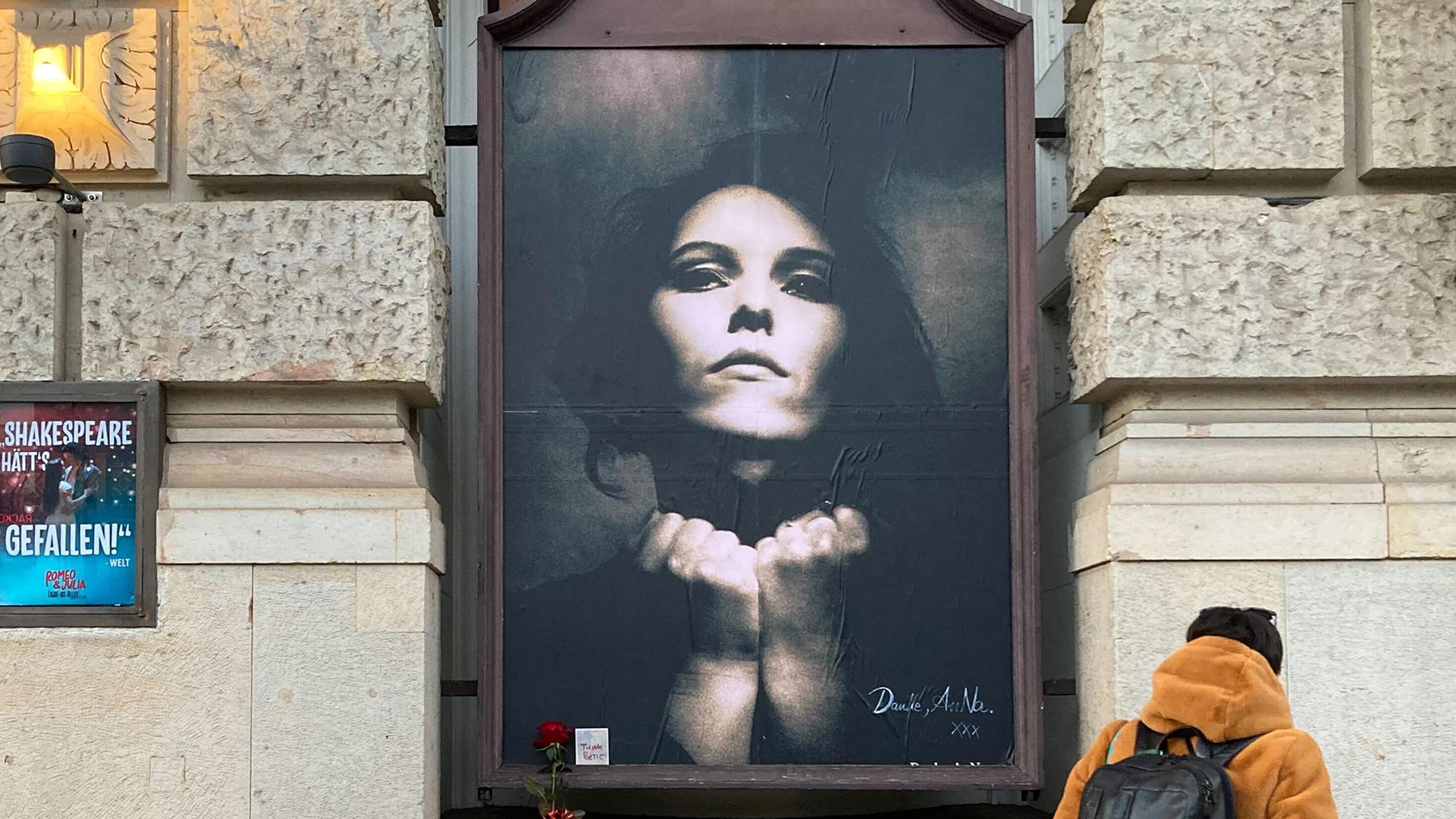 Eine Frau betrachtet einen Gedenkort für die verstorbene Rosenstolz-Sängerin Anna R. am Theater des Westens.