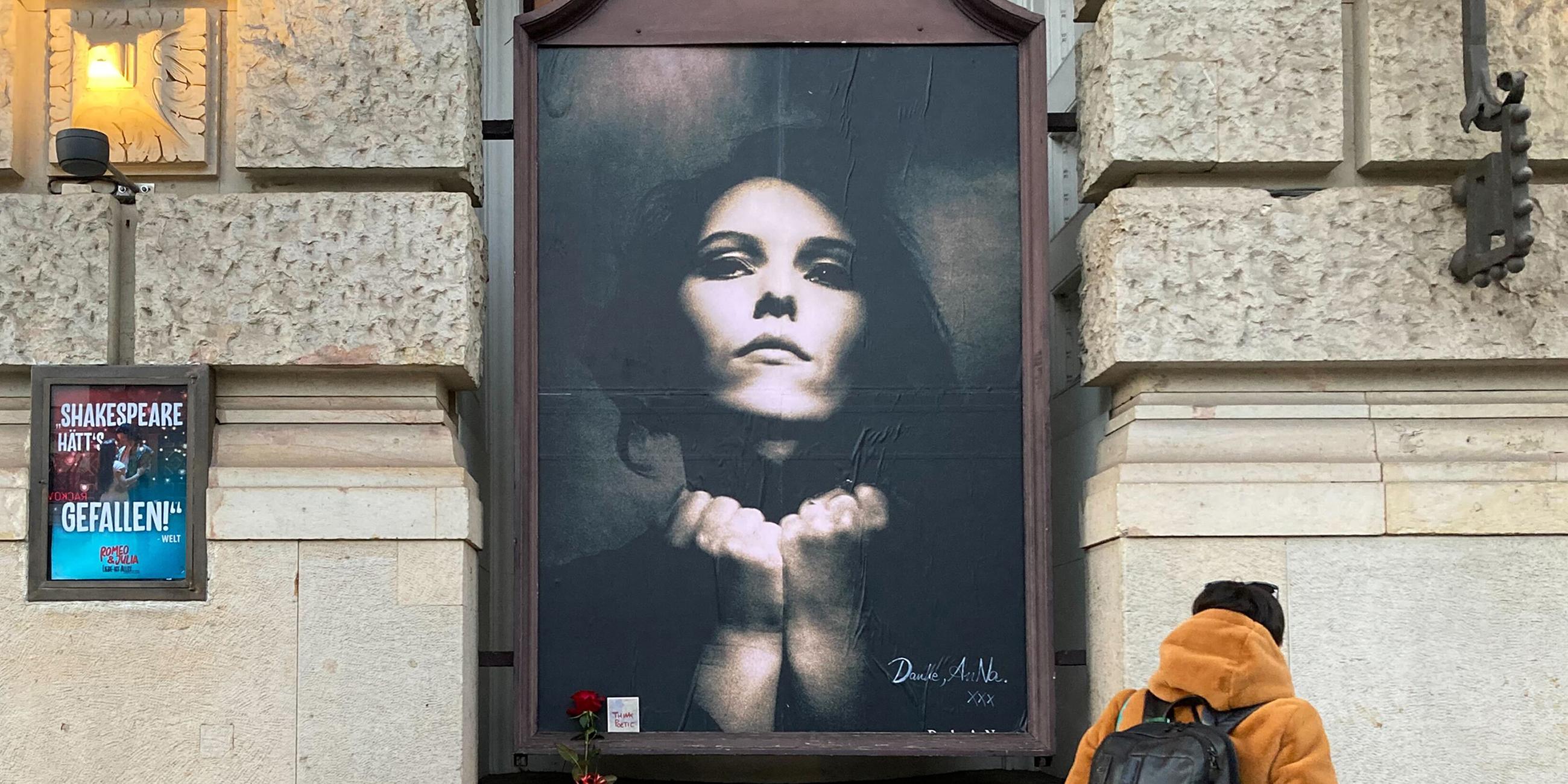 Eine Frau betrachtet einen Gedenkort für die verstorbene Rosenstolz-Sängerin Anna R. am Theater des Westens.