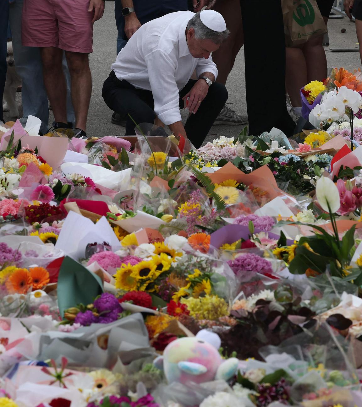 Menschen gedenken der Opfer es Anschlages am Bondi Beach in Sydney. 
