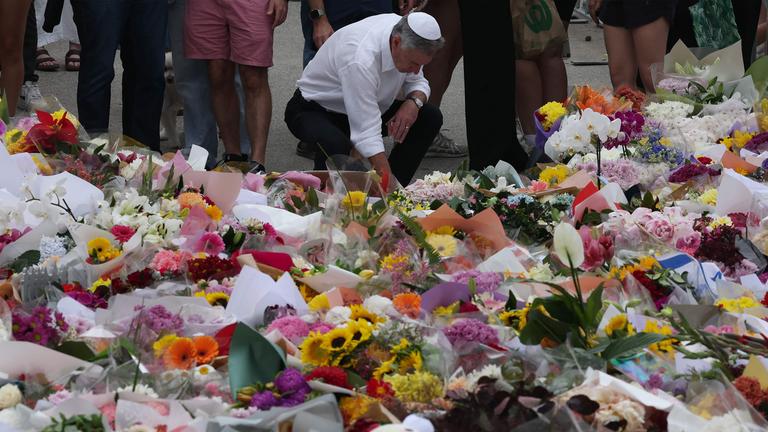 Menschen gedenken der Opfer es Anschlages am Bondi Beach in Sydney. 