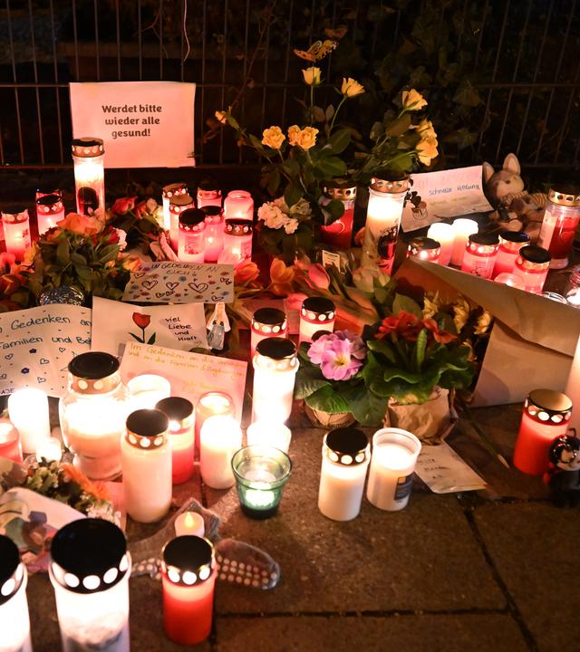 Blumen, Kerzen und Nachrichten liegen auf dem Gehweg in der Nähe der Stelle, wo ein Auto in eine Gruppe von Demonstranten gefahren war.