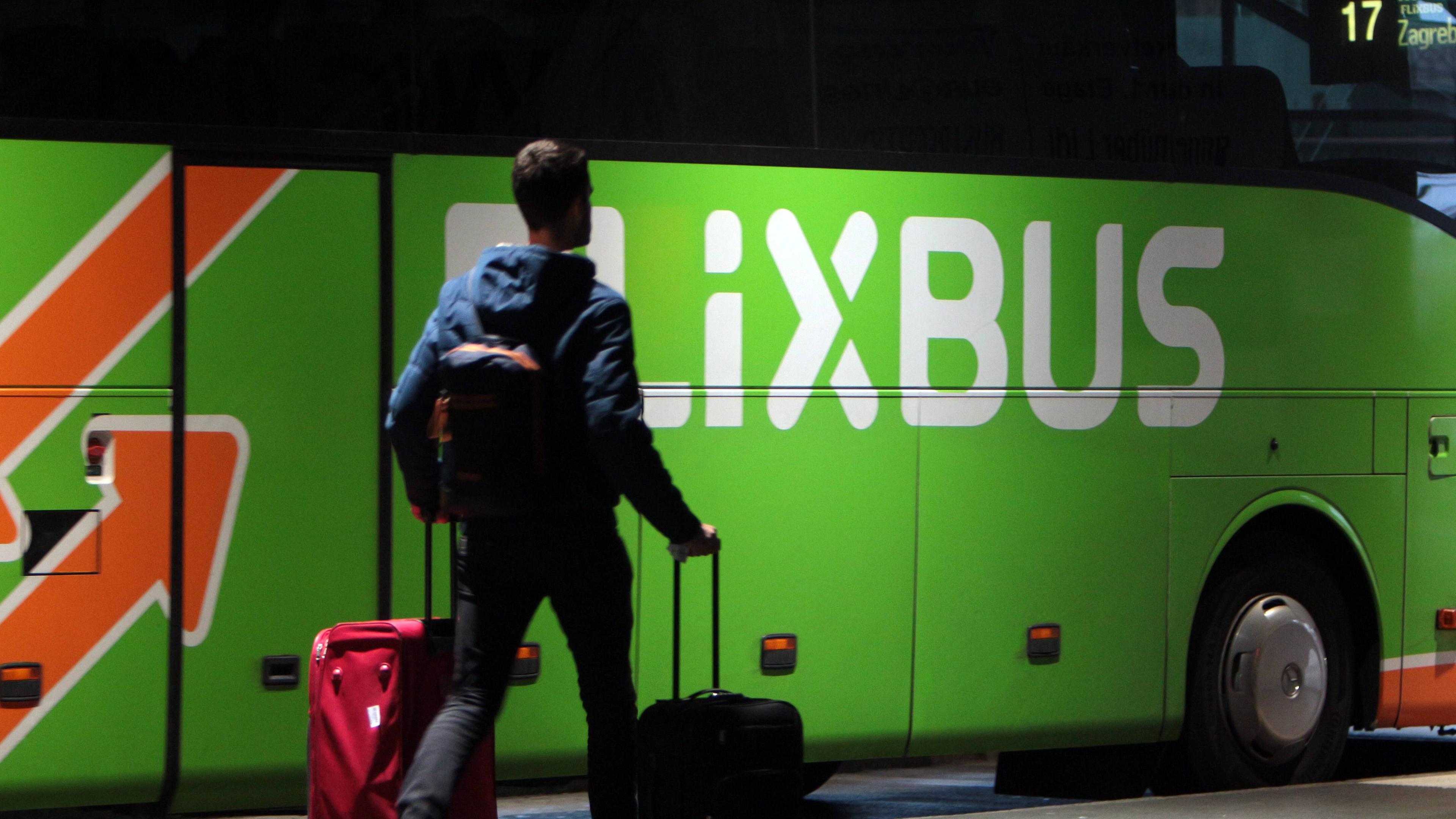 Mann steht mit Koffern vor einem FlixBus