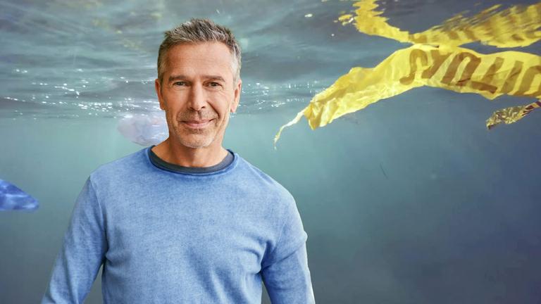 Ein gelbes Plastikband schwimmt im Wasser, im Vordergrund Dirk Steffens.