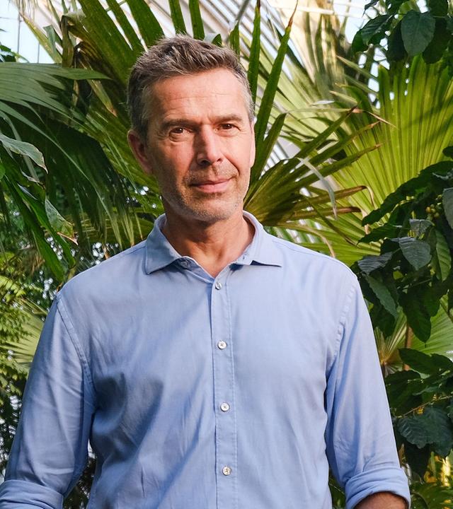 Dirk Steffens im Vordergrund, Blätter im Hintergrund.