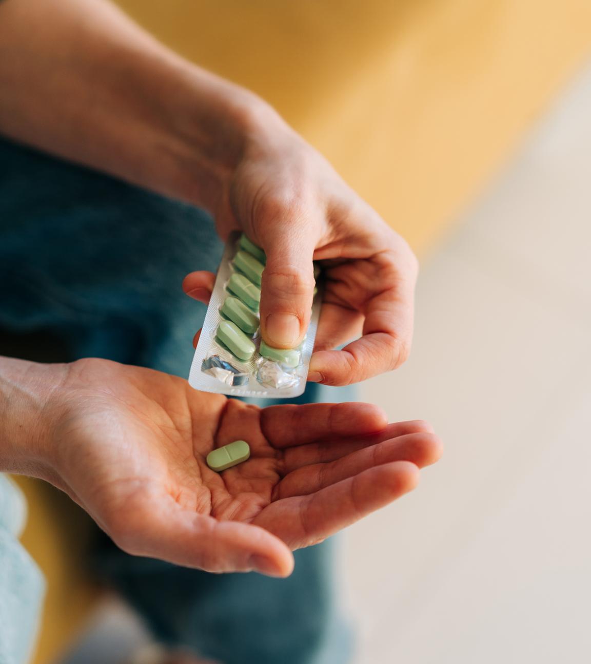 Nahaufnahme einer Packung Antidepressiva oder Schmerztabletten in Frauenhänden.