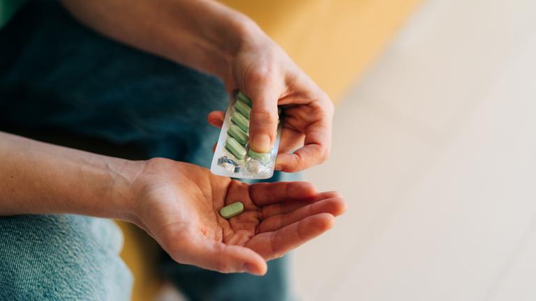 Nahaufnahme einer Packung Antidepressiva oder Schmerztabletten in Frauenhänden.