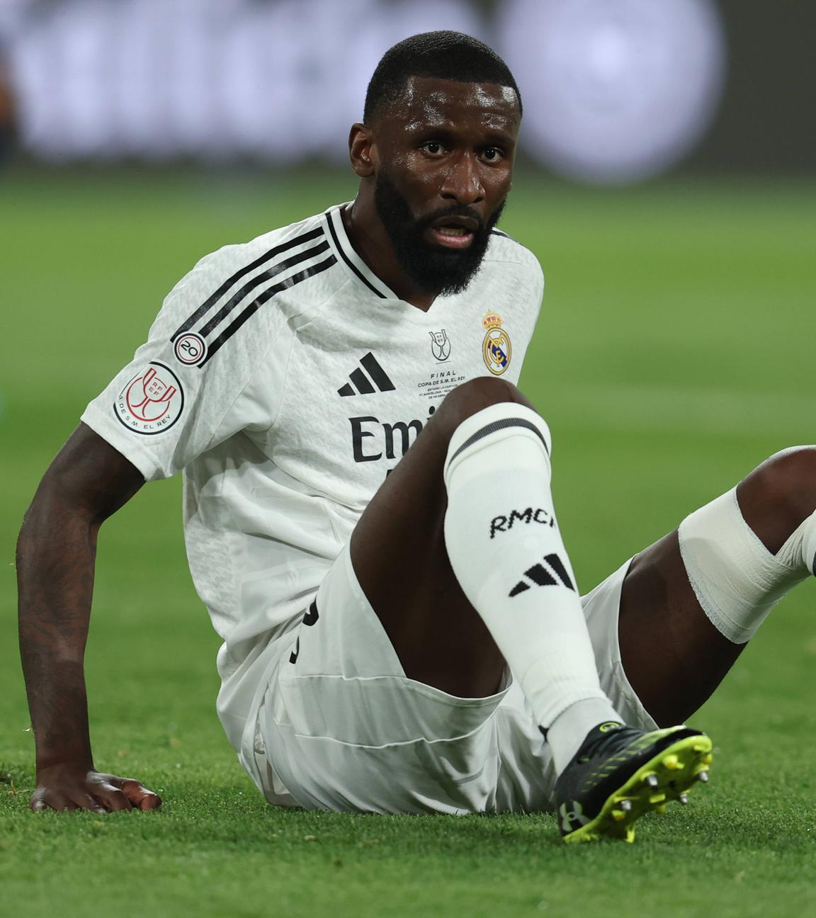 Fußballer Antonio Rüdiger auf dem Boden sitzend während des Fußballspiels in Sevilla am 26.04.2025