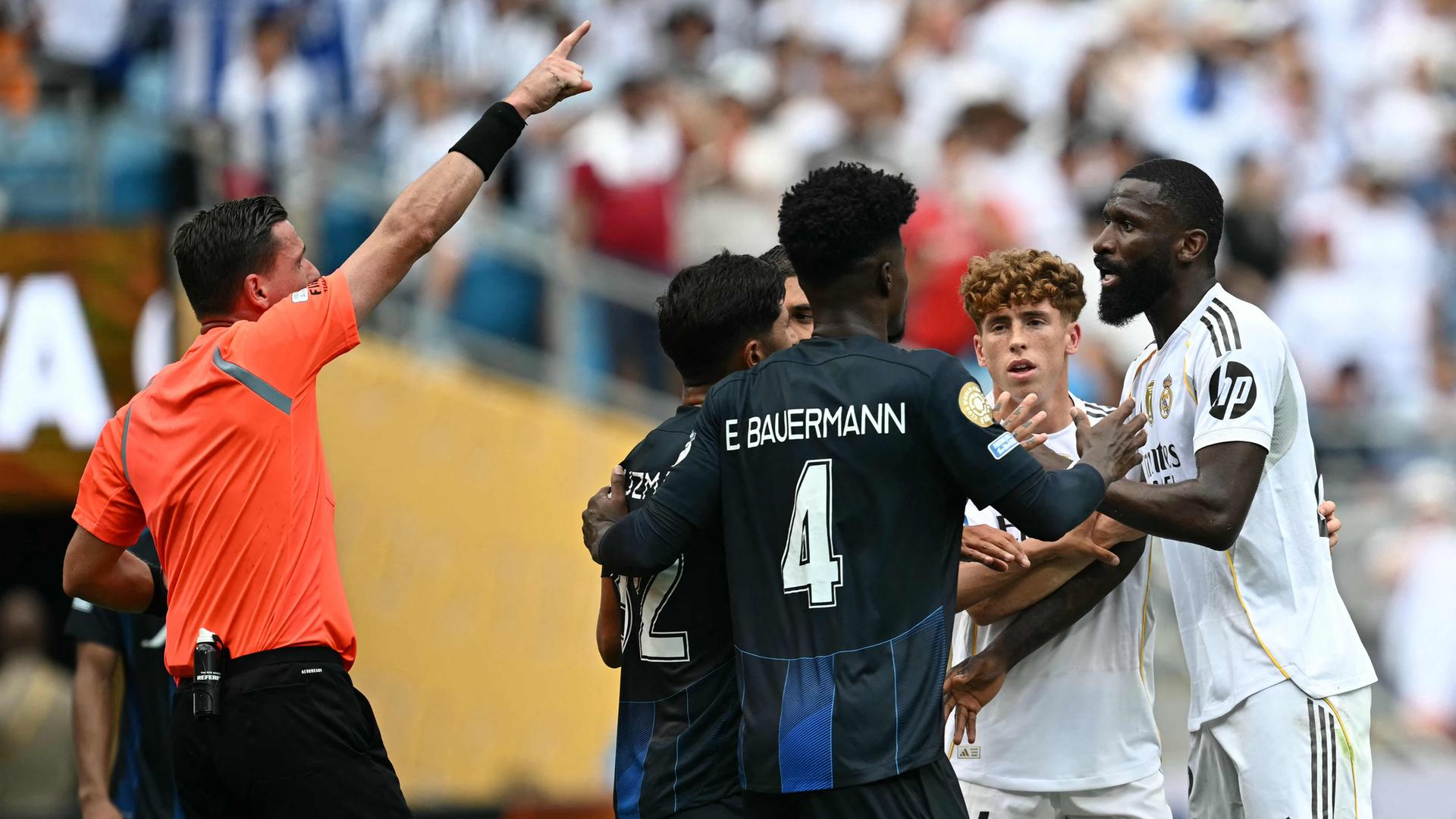 Der deutsche Verteidiger Antonio Rüdiger (R) von Real Madrid (Nr. 22) streitet sich mit dem brasilianischen Schiedsrichter Ramon Abatti (L) während des Fußballspiels der Gruppe H der FIFA Klub-Weltmeisterschaft 2025 zwischen Real Madrid (Spanien) und Pachuca (Mexiko) im Bank of America Stadium in Charlotte am 22. Juni 2025. 
