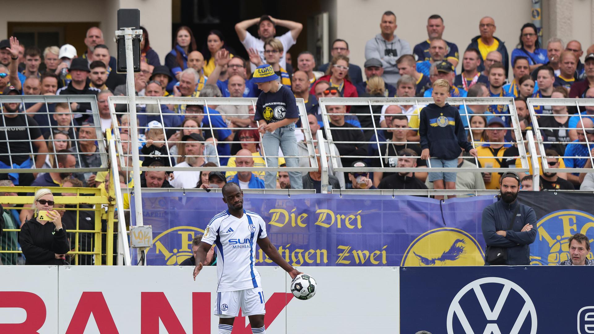 Der Schalker Spieler Christopher Antwi-Adjei steht an der Seitenlinie, um einen Einwurf auszuführen und hält den Ball in einer Hand.