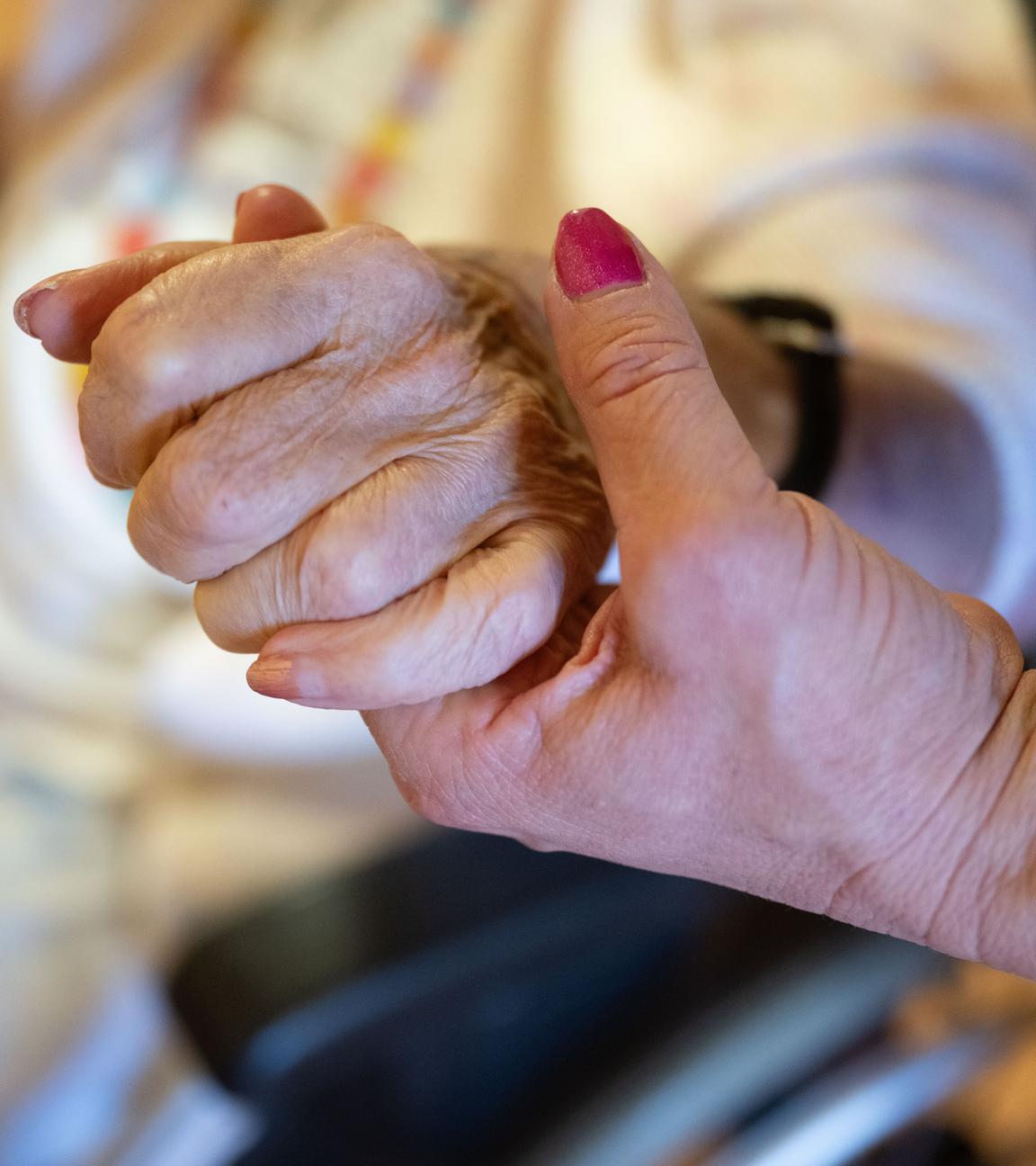 Pflegerin hält eine Hand