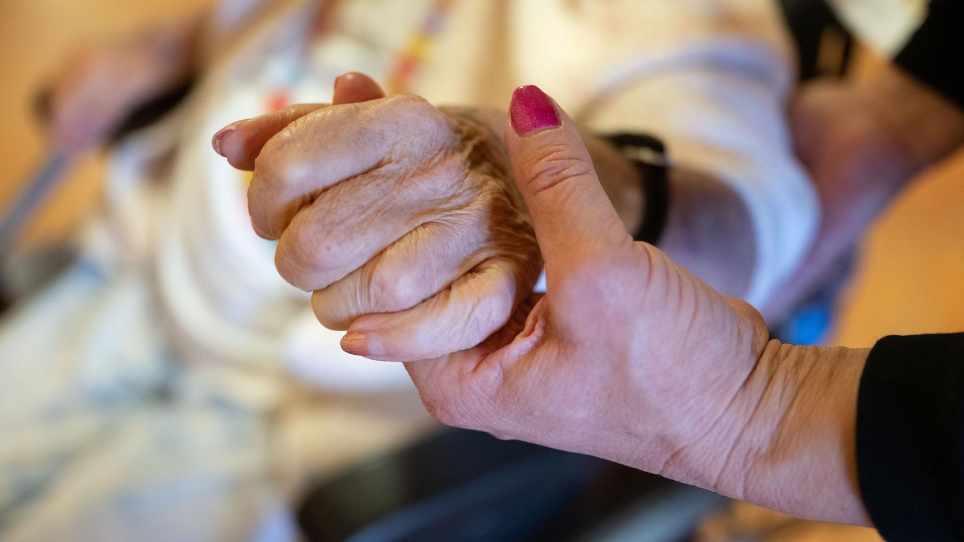Pflegerin hält eine Hand