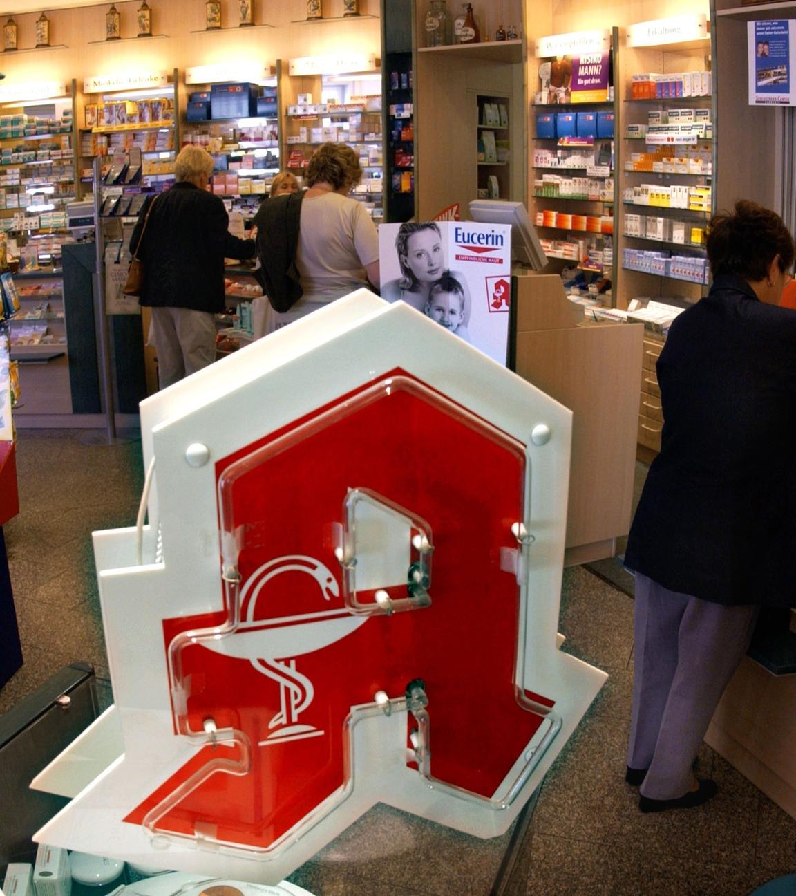 In einer Apotheke holen Kunden ihre Medikamente ab