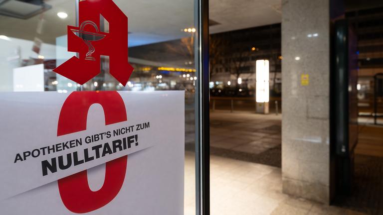 Ein Schild mit der Aufschrift Apotheken gibts nicht zum Nulltarif! hängt am Morgen im Schaufenster einer Apotheke in Berlin-Mitte