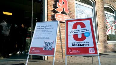 Aussenansicht Apotheke: ein rotes A an der Hauswand mit Hinweisschildern zum Streik in Hamburg.