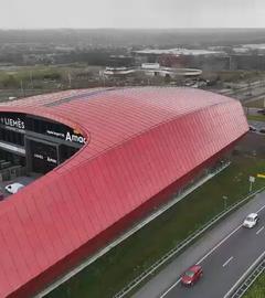 Ein rotes rundes Gebäude von oben, in dem die Ausstellung ist.