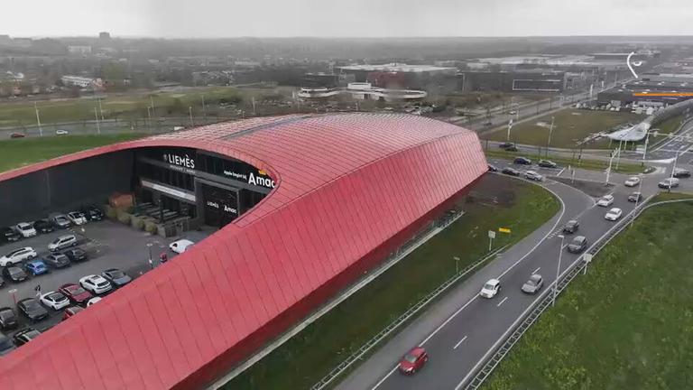 Ein rotes rundes Gebäude von oben, in dem die Ausstellung ist.