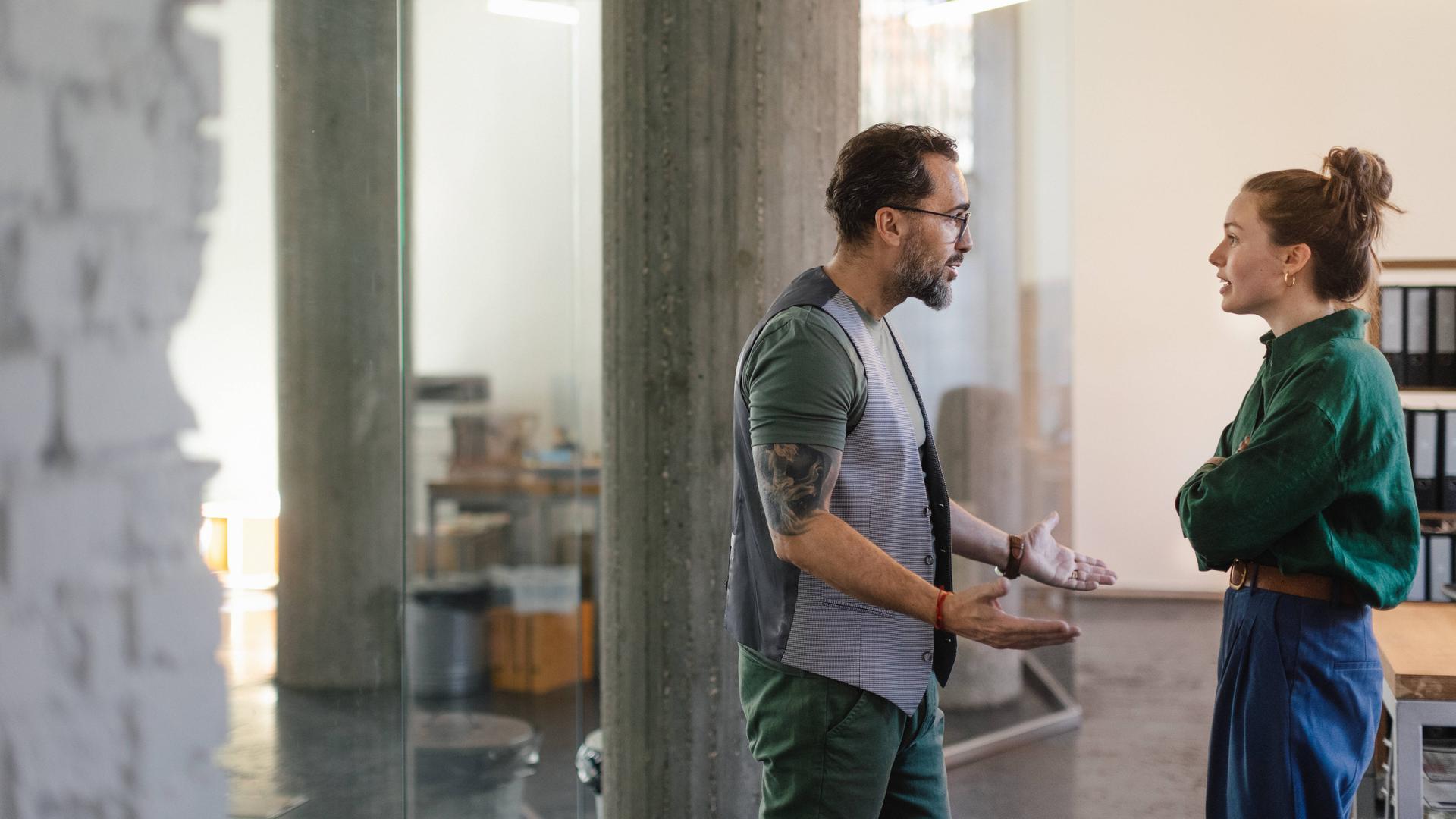 Mann und Frau stehen sich im Büro gegenüber.