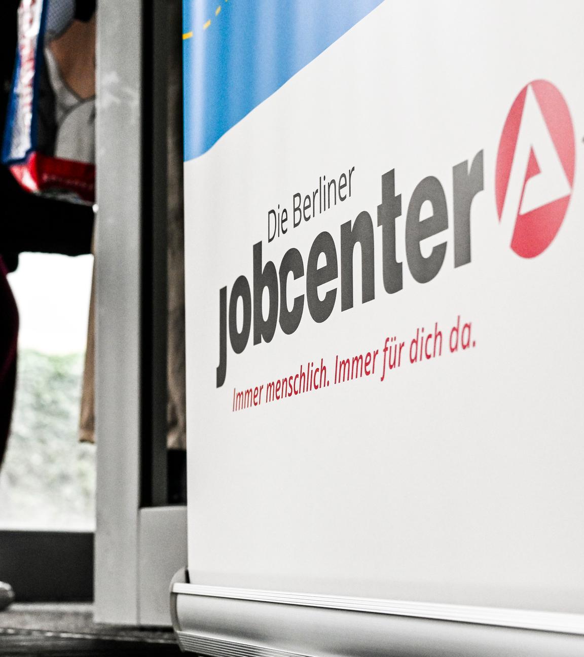 Symbolbild: Wartende Menschen stehen vor einem Jobcenter