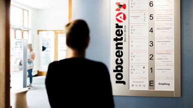 Eine Frau studiert die vom Jobcenter angebotenen Stellenausschreibungen