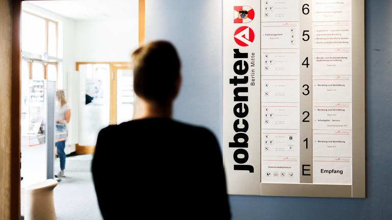 Eine Frau studiert die vom Jobcenter angebotenen Stellenausschreibungen