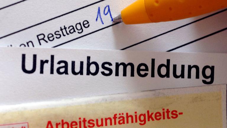 Übereinanderliegende Dokumente, wobei unten eine Urlaubsmeldung liegt, die von einer Arbeitsunfähigkeitsbescheinigung überdeckt wird