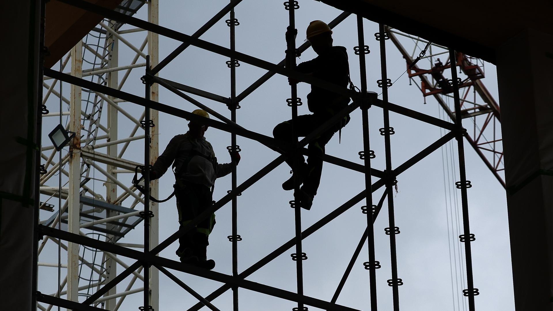 Symbolbild: Silhouetten von Bauarbeiten auf einer Baustelle