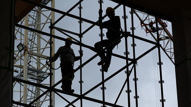 Symbolbild: Silhouetten von Bauarbeiten auf einer Baustelle