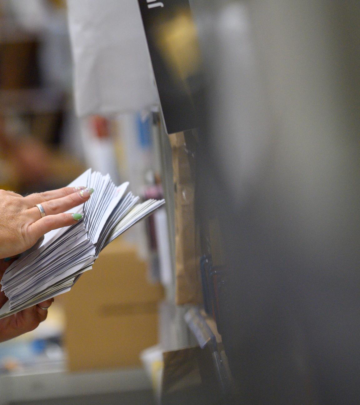 Mitarbeiter der Deutschen Post sortieren im Zustellstützpunkt Magdeburg-Buckau Briefe.