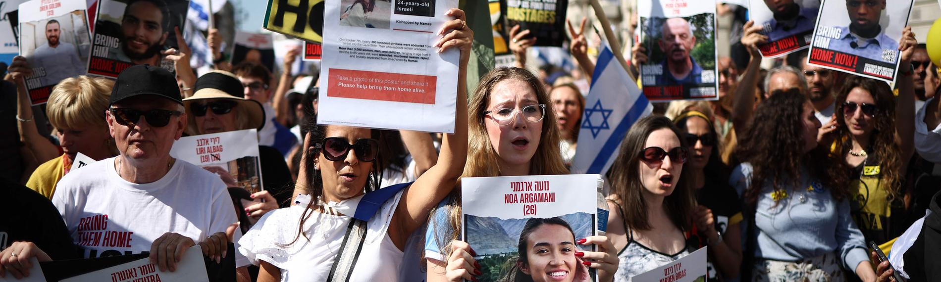 Demonstranten mit Plakaten, darunter eines mit der Geisel Noa Argamani 