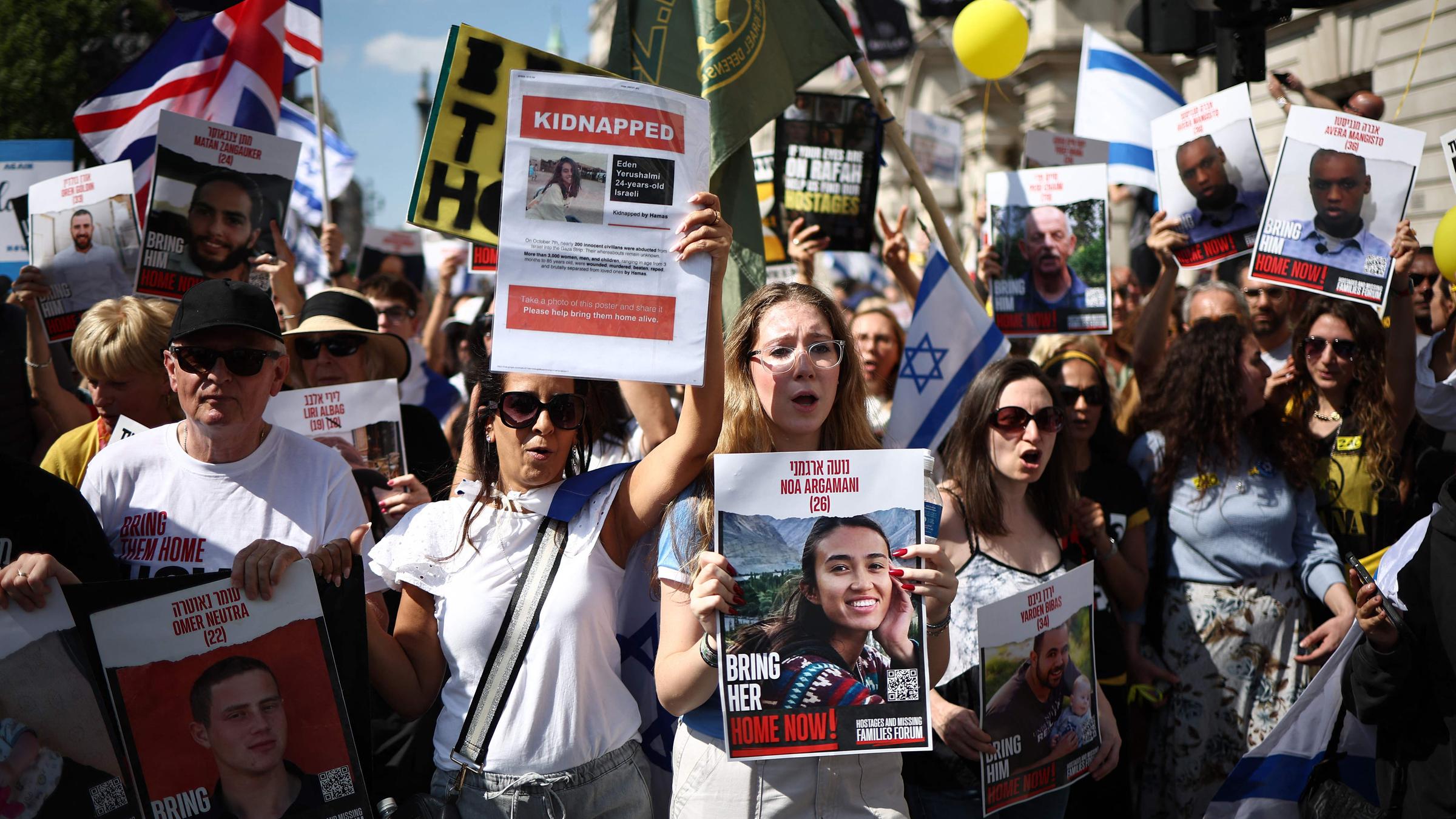 Demonstranten mit Plakaten, darunter eines mit der Geisel Noa Argamani 