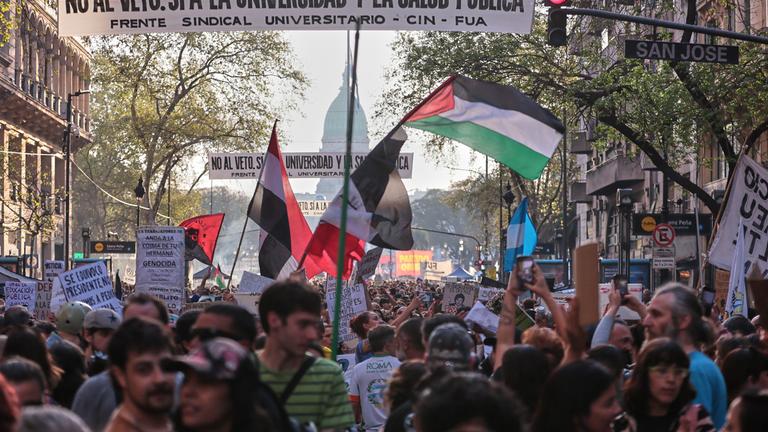 Demonstranten ziehen mit Schildern und Flaggen durch die argentinische Hauptstadt Buenos Aires