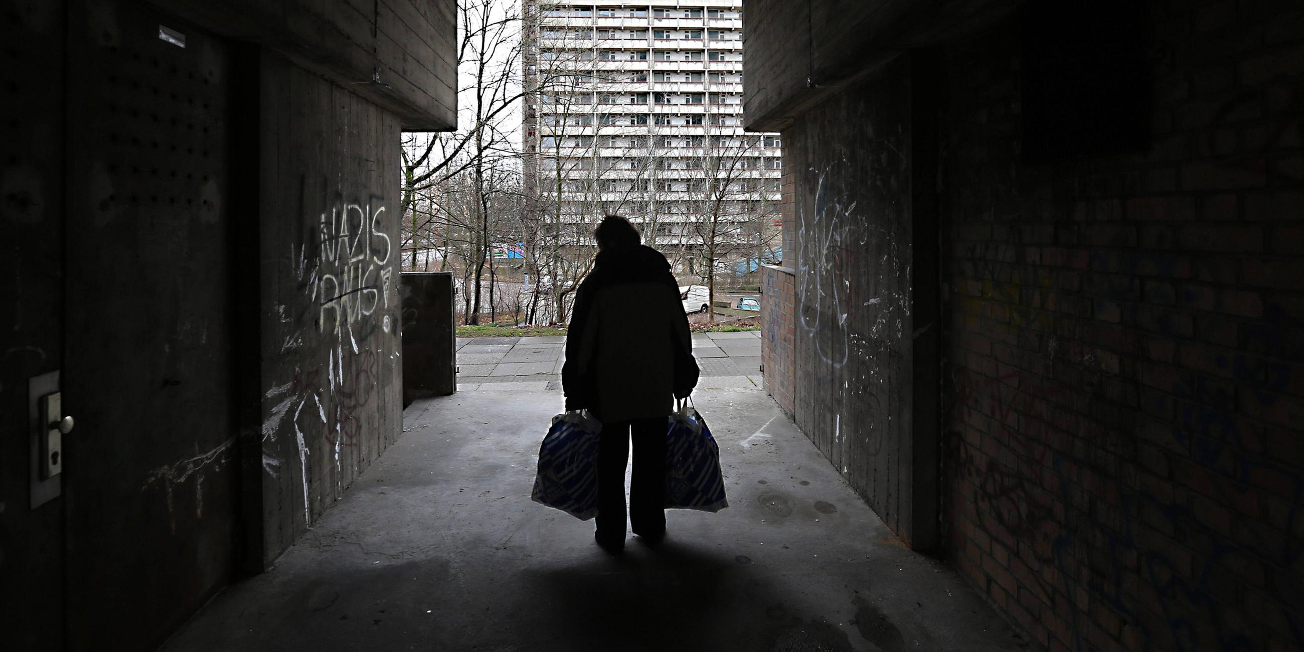 Archiv: Eine Frau in einer Unterfuehrung an einer Plattenbau-Siedlung in Halle-Neustadt am 21.02.2016