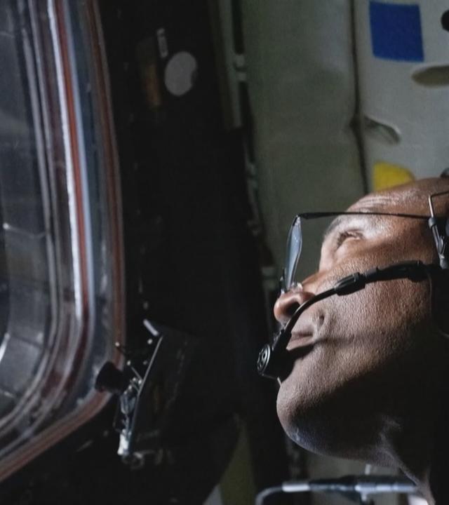 Astronaut schaut aus dem Fenster des Raumschiffs